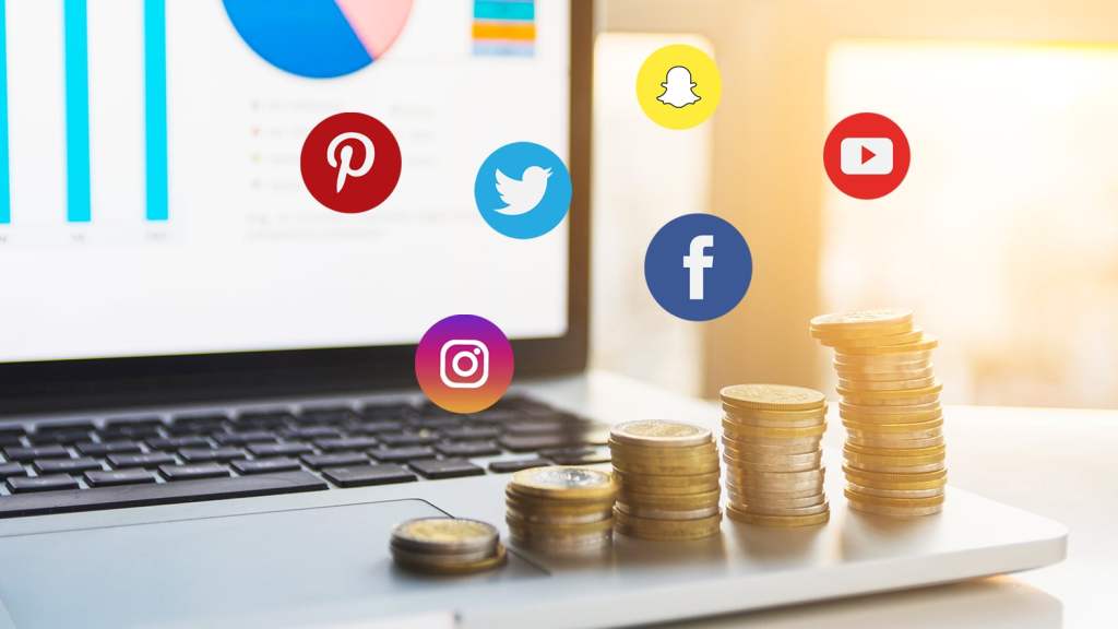 graphic with social media icons hovering over laptop with 5 stacks of gold coins on front right side of laptop.